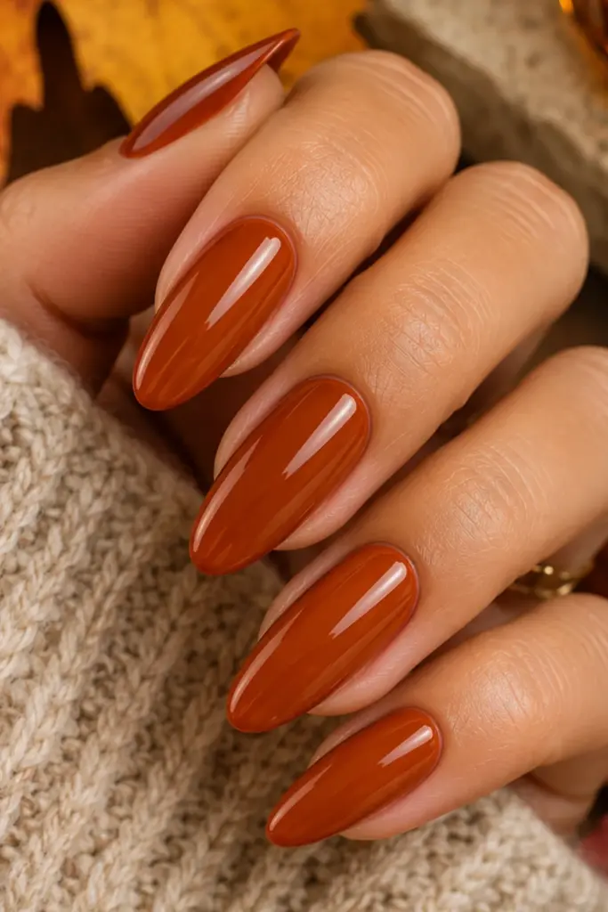 Burnt amber orange manicure with warm glossy autumn nails in a chic Pinterest-ready style.