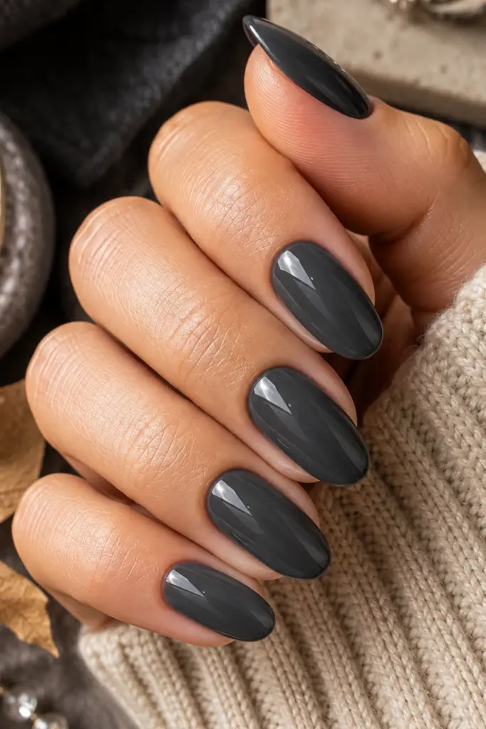 Charcoal smoked gray glossy manicure styled with elegant autumn textures for a classy fall nail look.