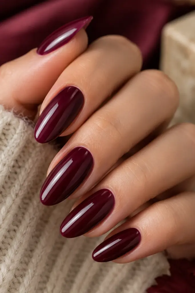 Deep burgundy wine manicure with elegant glossy nails in a sophisticated classy autumn style.
