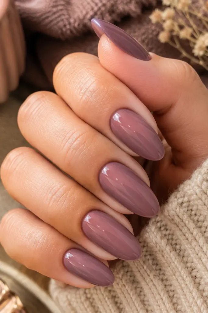 A muted dusty mauve manicure with soft glossy nails styled for a sophisticated, classy fall aesthetic.