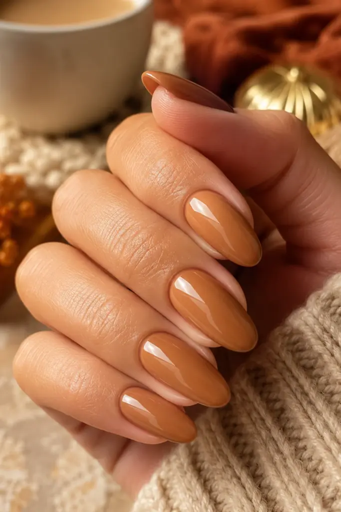 Warm caramel latte fall manicure with creamy glossy nails styled for a chic and classy autumn look.