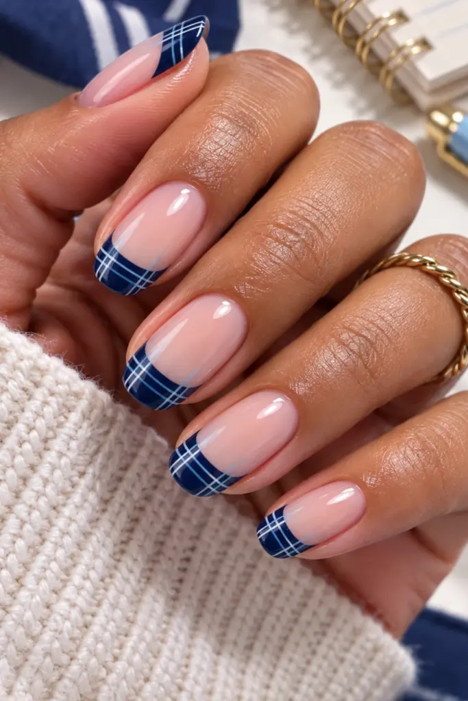 Navy plaid French tip nails with preppy blue, white, and pale-blue details on short polished nails, photographed in a colorful Pinterest style.