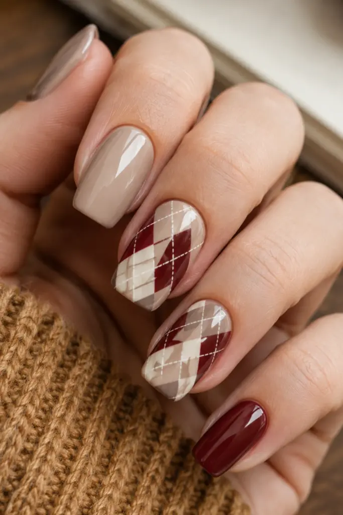 Trendy fall-inspired back-to-school argyle nail design featuring nude, burgundy, and cream plaid diamonds with a polished preppy finish.