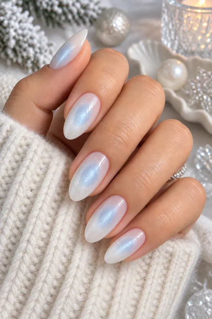 Frosted white aura winter nails with translucent milky layers and a soft snowy glow, styled for 2026.