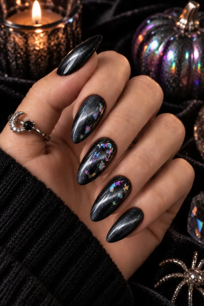 Charcoal cat-eye Halloween nails with dimensional magnetic shimmer and colorful holographic Halloween foil in a modern 2026 manicure.