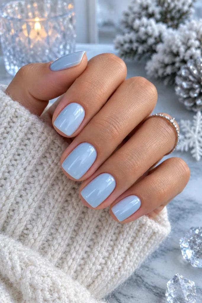 Glossy icy blue short winter nails with a cool luminous finish, modern styling, and polished 2026 manicure inspiration.