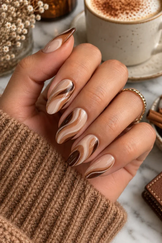 Caramel mocha swirl nails in creamy beige and warm brown tones, a cozy, sophisticated winter autumn manicure with a glossy finish.